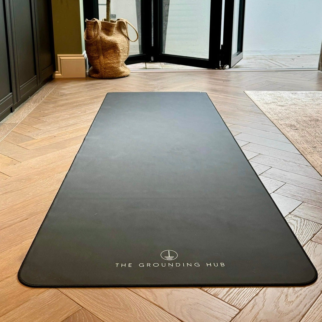 Our grounding yoga mat laid out on a bedroom floor