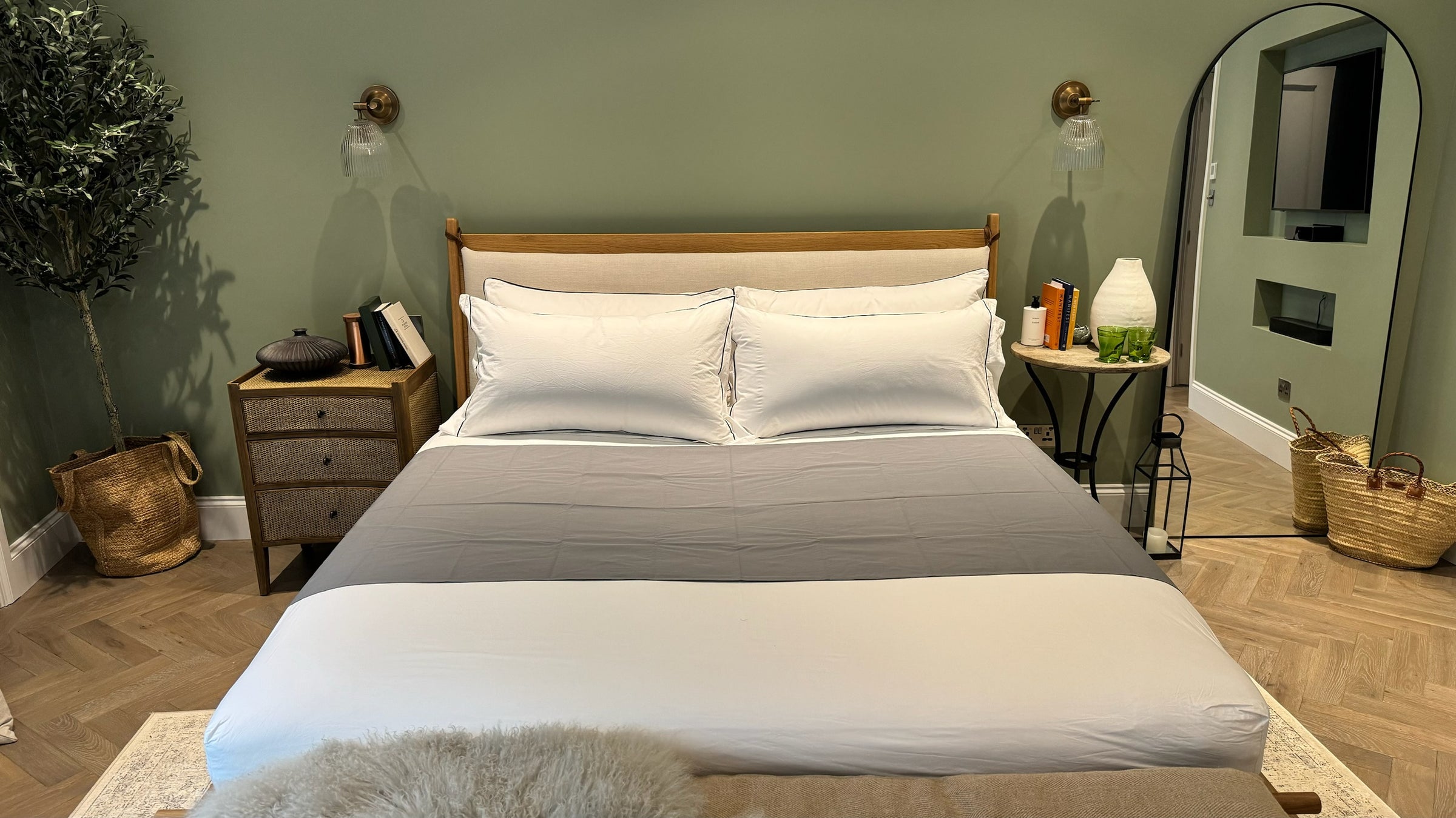 A superking size bed with a grey grounding bedsheet laid across