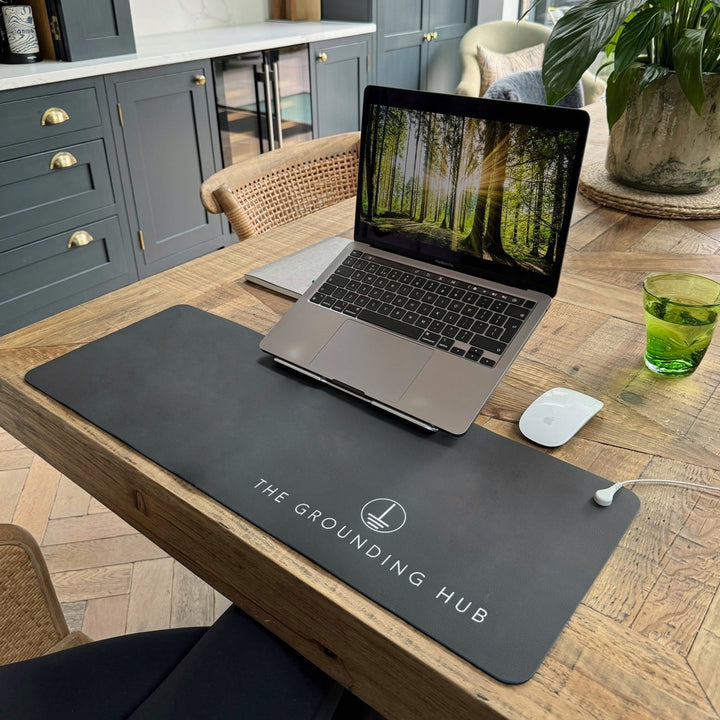 Our desk mat laid out on a working from home desk in a kitchen with laptop and mouse